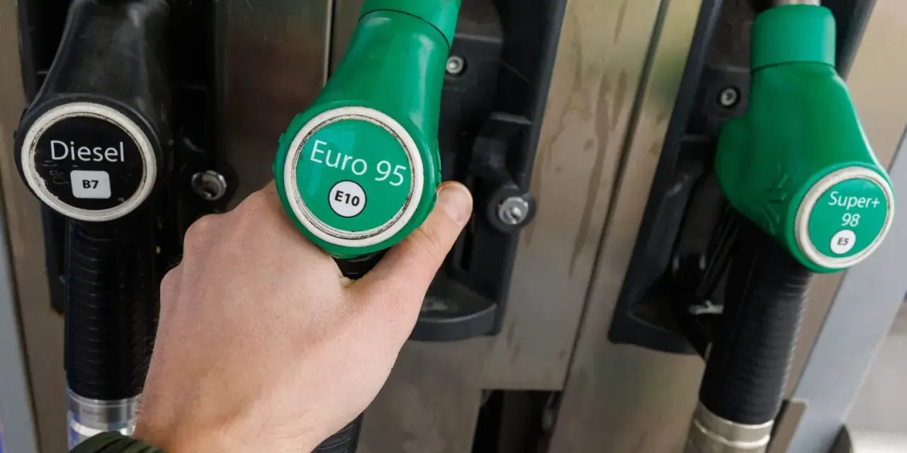 Dłoń trzymająca zielony pistolet z napisem "Euro 95 E10", obok pistolety na Diesel i Super+ 98.