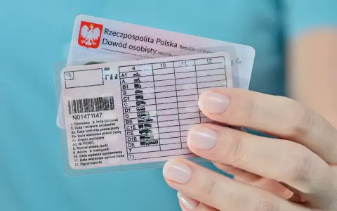 Polskie prawo jazdy z kategoriami, w tym kat. B, w dłoni. Dokumenty do prowadzenia pojazdów.