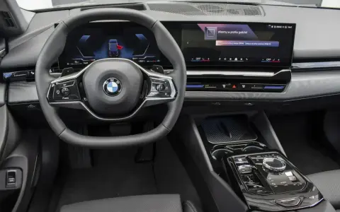 Wnętrze BMW 520d xDrive z nowoczesnym ekranem i kierownicą.