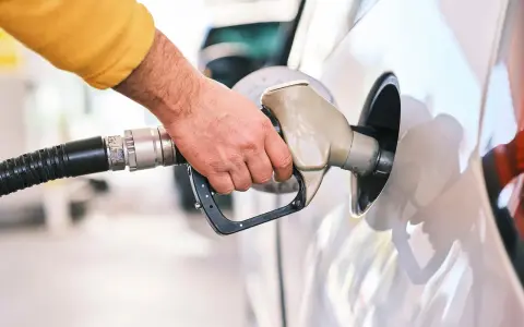 Tankowanie mojego Peugeota 307 2.0 HDI. Dłoń trzymająca pistolet paliwowy przy wlewie.