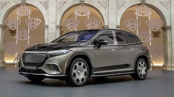 Elegancki Mercedes-Maybach EQS SUV w kolorze szaro-czarnym prezentuje się luksusowo na tle ozdobnych arkad z logo Maybach.