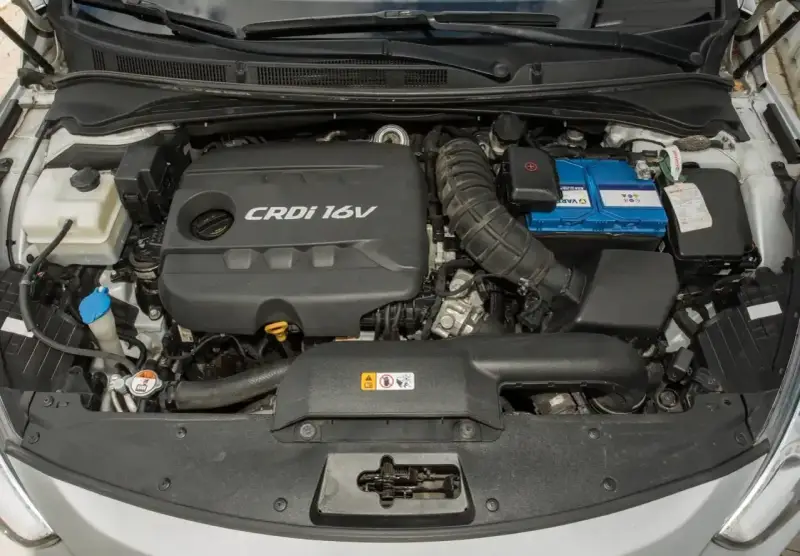 Silnik CRDi 16V w Kia Sportage 1.7 CRDi, z widocznym akumulatorem i elementami układu dolotowego.